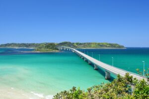 Scenic view of Tsunoshima Bridge spanning turquoise waters in Yamaguchi, Japan under a clear blue sky.